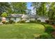 Beautifully landscaped front yard with lush green grass, mature trees, and a charming white exterior at 568 Timberland Dr, Atlanta, GA 30342