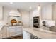 Modern kitchen with white cabinets, marble countertops, and stainless steel appliances at 568 Timberland Dr, Atlanta, GA 30342