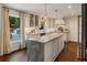 Modern kitchen with a marble island, stainless steel appliances, herringbone backsplash, and backyard views at 568 Timberland Dr, Atlanta, GA 30342