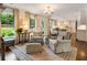 Bright living room featuring hardwood floors, stylish furniture, and an open view into the kitchen and backyard at 568 Timberland Dr, Atlanta, GA 30342
