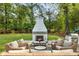 Cozy outdoor fireplace with seating area and a glimpse of the backyard play area, perfect for entertaining at 568 Timberland Dr, Atlanta, GA 30342