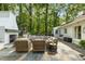 Inviting outdoor patio with stone fireplace, comfortable seating, and a play structure in the background at 568 Timberland Dr, Atlanta, GA 30342