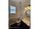 Powder room featuring a toilet and vanity with a marble countertop and round mirror at 7030 Bennington Ln, Cumming, GA 30041