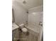 Bathroom with white tiled shower/tub, toilet, sink and gray countertop at 7030 Bennington Ln, Cumming, GA 30041