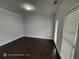 Bright, neutral bedroom with hardwood floors, and large windows providing ample natural light and outdoor views at 7030 Bennington Ln, Cumming, GA 30041