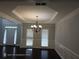 Elegant dining room featuring decorative ceilings, wainscoting, a chandelier, and large window with natural light at 7030 Bennington Ln, Cumming, GA 30041
