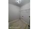 Minimalist laundry room with tile floors, neutral walls and a single wire shelf at 7030 Bennington Ln, Cumming, GA 30041