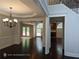 Open-concept living room with hardwood floors, archways, fireplace and large windows offering plenty of natural light at 7030 Bennington Ln, Cumming, GA 30041