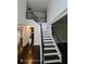 Elegant staircase featuring dark wood steps and wrought iron railings, leading to a brightly lit upper level at 7030 Bennington Ln, Cumming, GA 30041