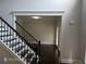 Beautiful staircase with hardwood steps and decorative iron railing, leading to an open area with abundant natural light at 7030 Bennington Ln, Cumming, GA 30041