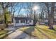 A quaint, single-story house on a sunny lot with mature trees and a concrete driveway at 1870 Oak Valley Rd, Decatur, GA 30035
