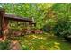 Charming backyard featuring a wooden deck, stone walkway, and lush landscaping at 2208 Guinevere Ne Way, Atlanta, GA 30345