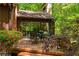 A wooden deck with outdoor dining set overlooking the verdant backyard is the perfect place for outdoor entertaining at 2208 Guinevere Ne Way, Atlanta, GA 30345