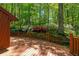 A spacious wooden deck with beautiful landscaping overlooks the vibrant backyard, surrounded by mature trees in full bloom at 2208 Guinevere Ne Way, Atlanta, GA 30345