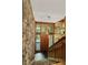 Foyer featuring stone wall, staircase, and stylish pendant lighting at 2208 Guinevere Ne Way, Atlanta, GA 30345