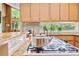A kitchen features stainless appliances, granite counters, and a gas cooktop. The window overlooks backyard landscaping at 2208 Guinevere Ne Way, Atlanta, GA 30345