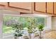 A well-lit kitchen window provides a lush view of the outdoors. Potted plants sit on the countertop at 2208 Guinevere Ne Way, Atlanta, GA 30345