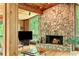 Spacious living room with hardwood floors, stone fireplace, wooden accents, and views of greenery at 2208 Guinevere Ne Way, Atlanta, GA 30345