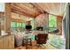Spacious living room with wood-paneled walls, stone fireplace, and large windows offering scenic views of the outdoors at 2208 Guinevere Ne Way, Atlanta, GA 30345