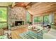 Inviting living room with stone fireplace, hardwood floors, and expansive windows overlooking the lush outdoor scenery at 2208 Guinevere Ne Way, Atlanta, GA 30345