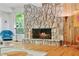 Charming living room showcasing a stone fireplace, hardwood floors, and bright window views at 2208 Guinevere Ne Way, Atlanta, GA 30345