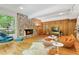 Spacious living room with stone fireplace, wood paneling, and stylish mid-century modern furniture at 2208 Guinevere Ne Way, Atlanta, GA 30345