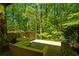 A relaxing outdoor patio space is surrounded by a stone wall that offers seclusion and an incredible natural view at 2208 Guinevere Ne Way, Atlanta, GA 30345