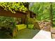 Outdoor patio with comfortable seating and a stone privacy wall surrounded by lush greenery at 2208 Guinevere Ne Way, Atlanta, GA 30345