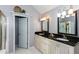 A bathroom features a double sink vanity with black granite countertops and a white-tiled floor at 3011 Oak Hampton Ct, Duluth, GA 30096