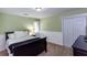 A secondary bedroom boasts green walls, white wainscoting, and double door closet at 3011 Oak Hampton Ct, Duluth, GA 30096