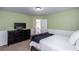 A secondary bedroom boasts green walls, white wainscoting, and a dark wood TV console at 3011 Oak Hampton Ct, Duluth, GA 30096