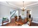 A dining room boasting wood floors, a decorative chandelier, and seamless access to the staircase and kitchen area at 3011 Oak Hampton Ct, Duluth, GA 30096