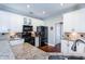 Modern kitchen features white cabinets, granite countertops, and black appliances at 3011 Oak Hampton Ct, Duluth, GA 30096