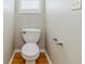 Half bath with white toilet, wood laminate floor and neutral color walls at 4357 James Wade Dr, Snellville, GA 30039