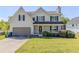 Charming two-story home with a well-manicured front yard, covered porch, and attached garage at 4357 James Wade Dr, Snellville, GA 30039