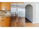 Kitchen with wooden cabinets and stainless steel refrigerator and access to the stairs at 4357 James Wade Dr, Snellville, GA 30039