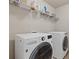 Convenient laundry room featuring a washer, dryer, and storage shelving at 81 Creekside Bluff Way, Auburn, GA 30011