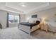 Serene main bedroom with a tray ceiling, neutral tones, and abundant natural light at 81 Creekside Bluff Way, Auburn, GA 30011