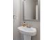 Charming powder room featuring a pedestal sink and a decorative mirror at 81 Creekside Bluff Way, Auburn, GA 30011