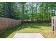 Private backyard with a wooden fence and a small patio area, surrounded by lush greenery and trees at 8475 Douglass Trl, Jonesboro, GA 30236