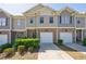 Inviting townhome exterior featuring brick accents, garage, and well-maintained landscaping at 8475 Douglass Trl, Jonesboro, GA 30236