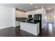 Bright kitchen features white cabinets, black appliances and countertops, and a large island with sink at 8475 Douglass Trl, Jonesboro, GA 30236