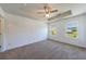 Spacious main bedroom with tray ceiling, ceiling fan, carpet, and two windows at 8475 Douglass Trl, Jonesboro, GA 30236