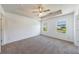 Bright main bedroom features neutral decor, carpet flooring, a tray ceiling, and windows at 8475 Douglass Trl, Jonesboro, GA 30236