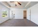 Spacious main bedroom with tray ceiling, ceiling fan, carpet, and multiple doorways at 8475 Douglass Trl, Jonesboro, GA 30236