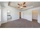 Bright main bedroom features neutral decor, carpet flooring, a tray ceiling, and en-suite bathroom at 8475 Douglass Trl, Jonesboro, GA 30236