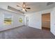 Bright main bedroom features neutral decor, carpet flooring, a ceiling fan, and a walk-in closet at 8475 Douglass Trl, Jonesboro, GA 30236