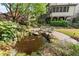 Landscaped backyard with a serene koi pond, lush greenery, and patio seating for relaxation and outdoor enjoyment at 3749 Watkins Ne Pl, Brookhaven, GA 30319