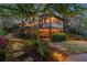 Inviting backyard with multi-level deck, outdoor lighting, and stone pathways surrounded by mature trees at 3749 Watkins Ne Pl, Brookhaven, GA 30319