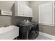 Functional laundry room with front load washer/dryer, sink and storage at 3749 Watkins Ne Pl, Brookhaven, GA 30319